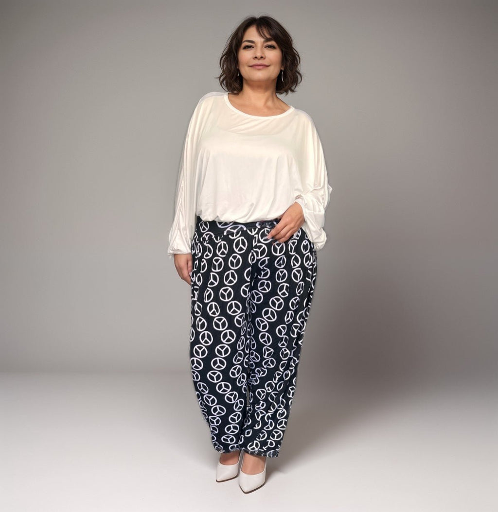 Comfortable plus-size white top paired with patterned black pants featuring peace signs.