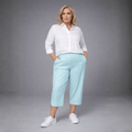 Light blue linen culottes featuring side pockets, paired with a white button-up shirt.