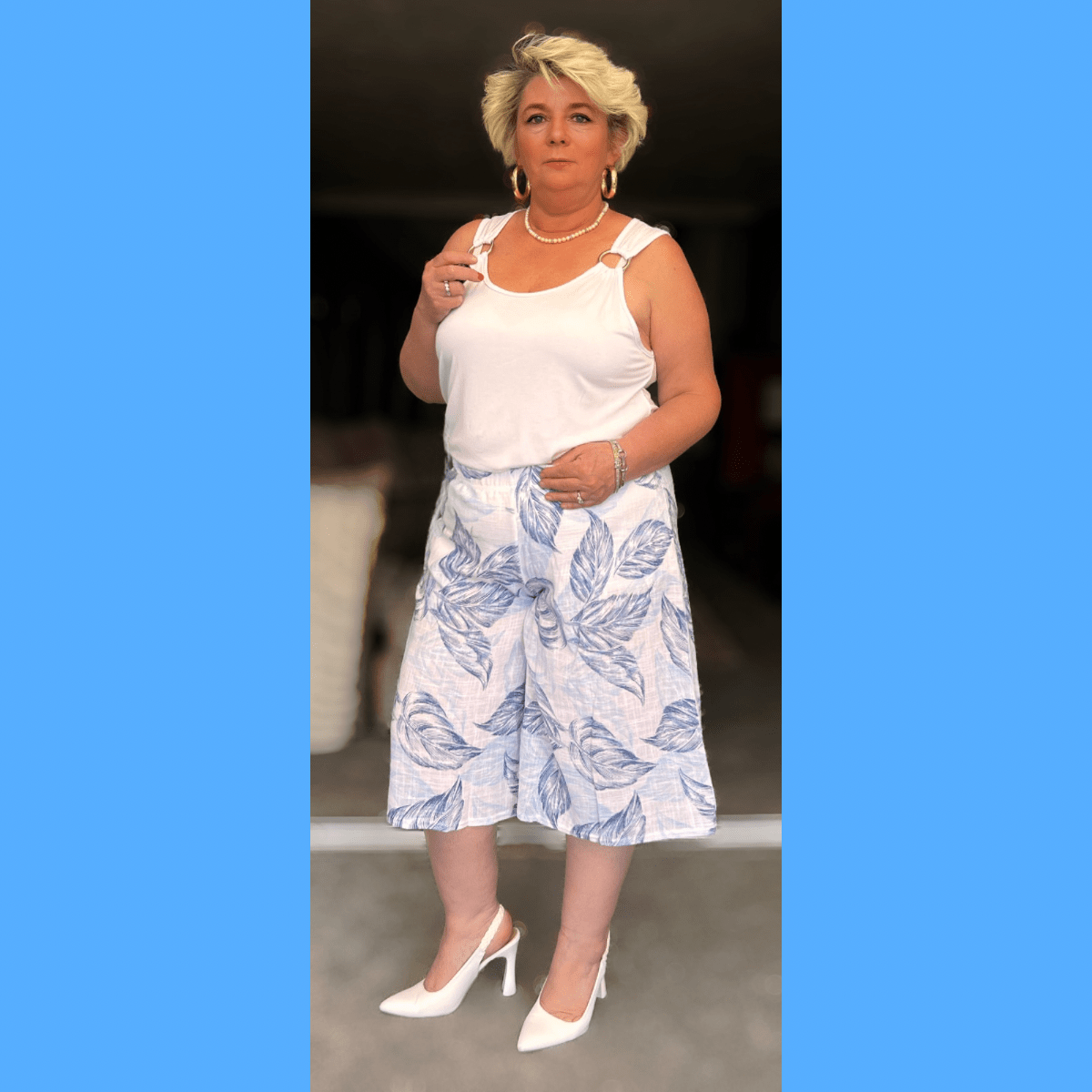 Stylish Floral Skirt featuring a blue leaf pattern, paired with a white tank top and heels.