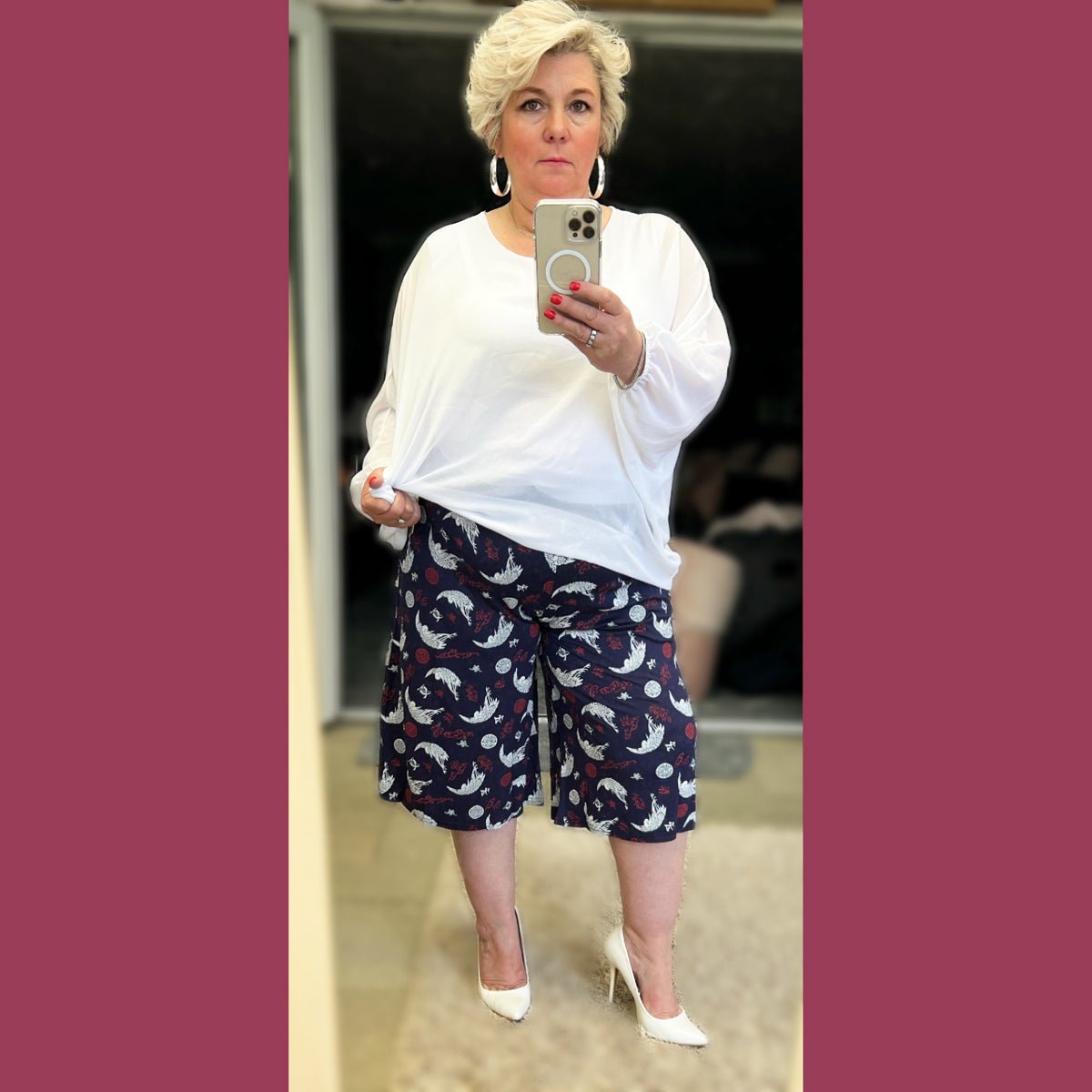 Stylish white oversized top paired with patterned shorts, perfect for casual outings.
